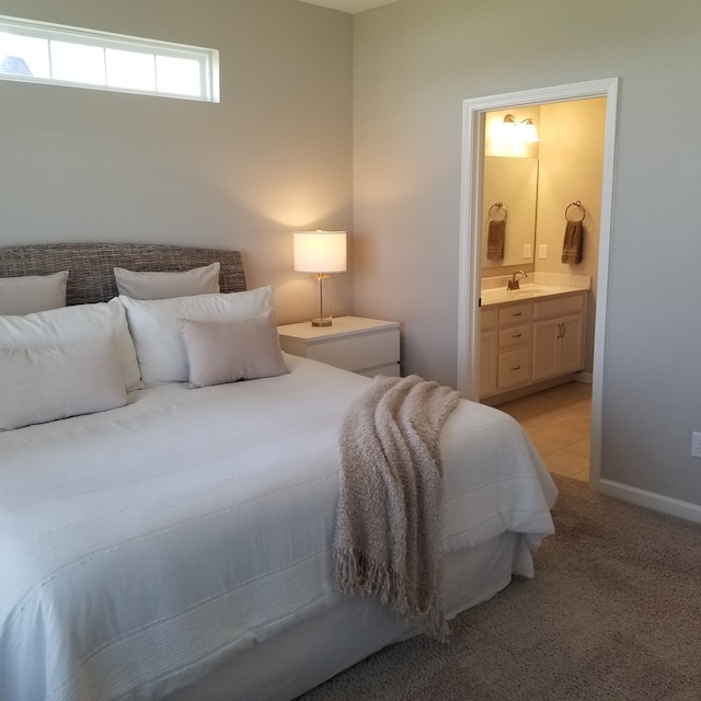 carpeted bedroom with connected bathroom and sink