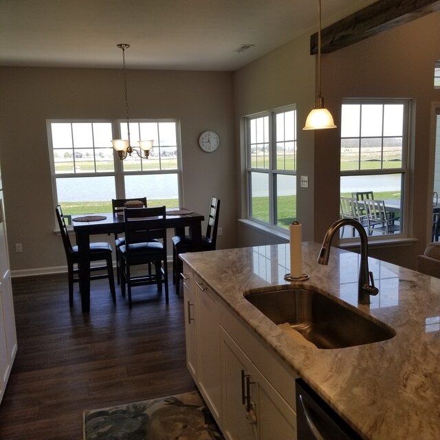 kitchen with sink, pendant lighting, dark hardwood / wood-style floors, and light stone counters