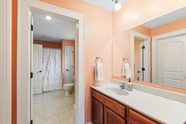 bathroom featuring tile floors, vanity, and toilet