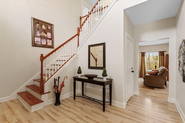 stairway with light hardwood / wood-style floors