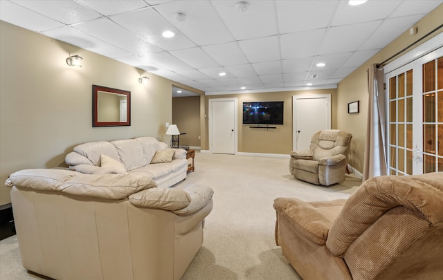 living room with a paneled ceiling, carpet, and french doors