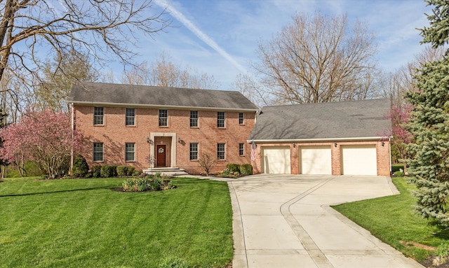 colonial inspired home featuring a garage and a front lawn