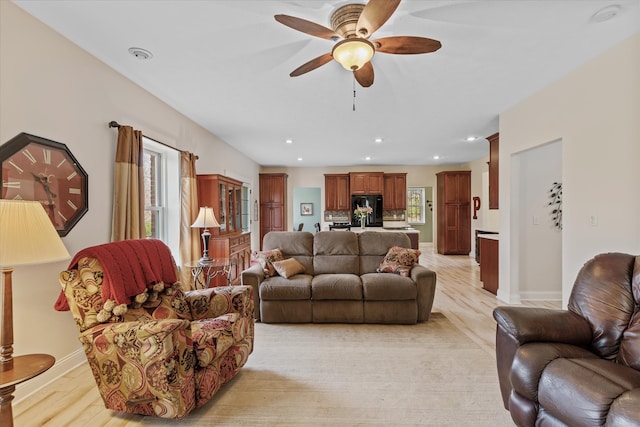 living room with ceiling fan and light wood-type flooring