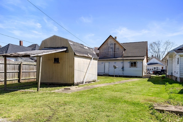 back of property with a lawn and a storage shed