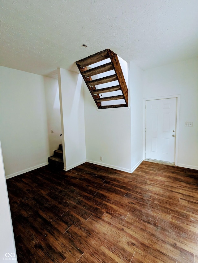 bonus room with a textured ceiling and dark hardwood / wood-style floors