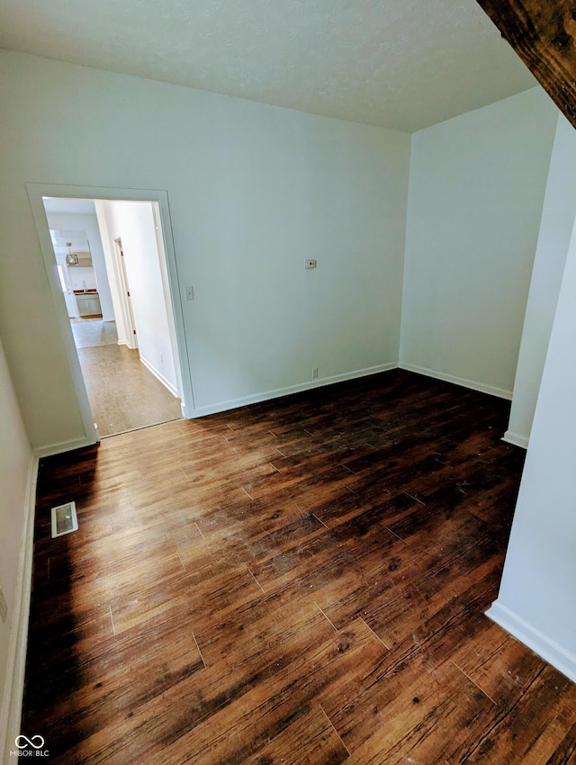 unfurnished room with dark hardwood / wood-style flooring