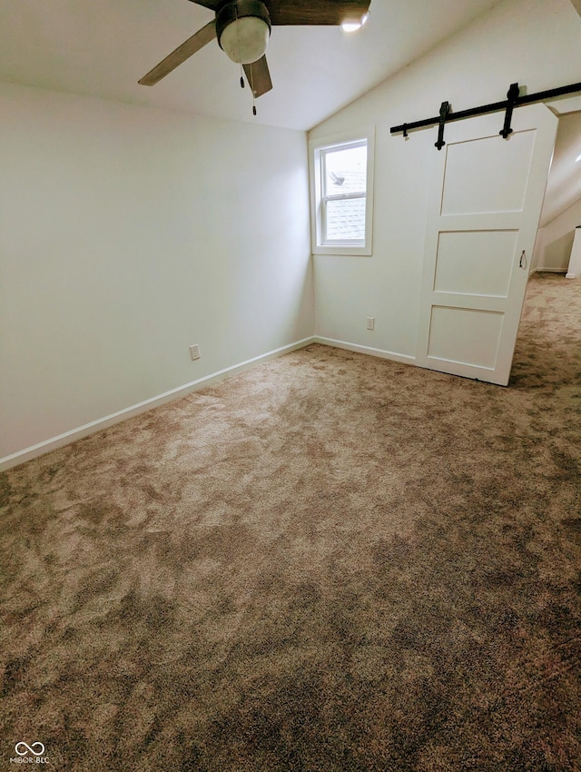 unfurnished room with carpet, a barn door, ceiling fan, and lofted ceiling