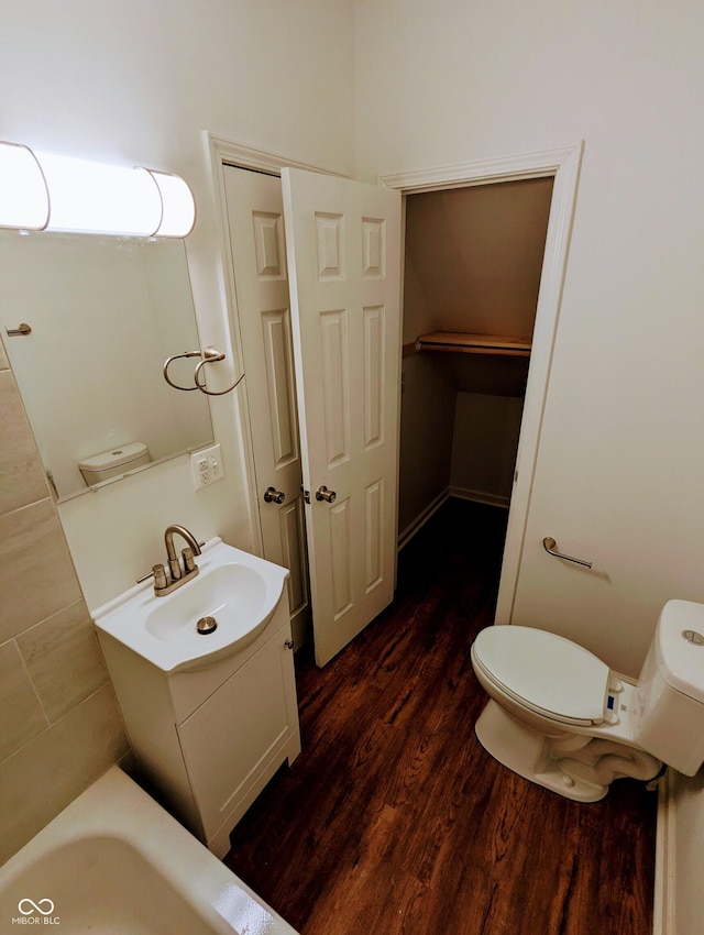 bathroom featuring wood-type flooring, vanity, and toilet