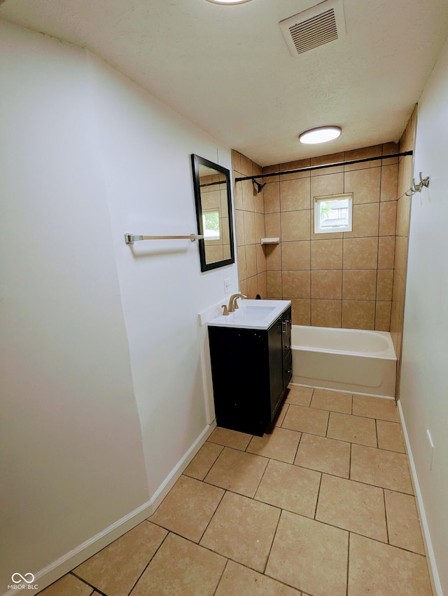 bathroom featuring tile patterned floors, tiled shower / bath combo, and vanity