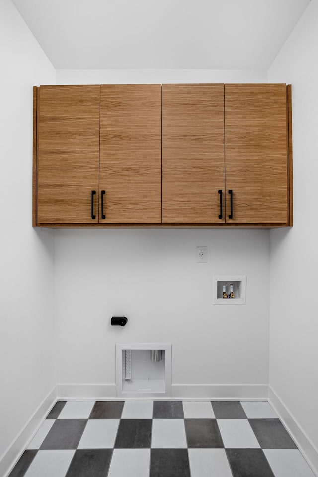 laundry room with cabinets, dark tile flooring, and hookup for a washing machine