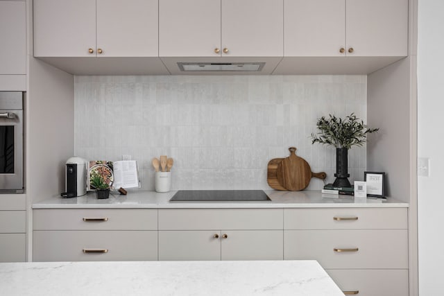 kitchen with oven, backsplash, and black electric stovetop