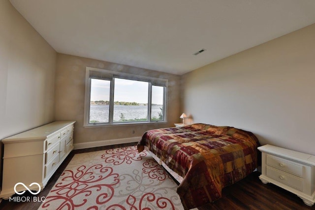 bedroom featuring a water view and hardwood / wood-style floors