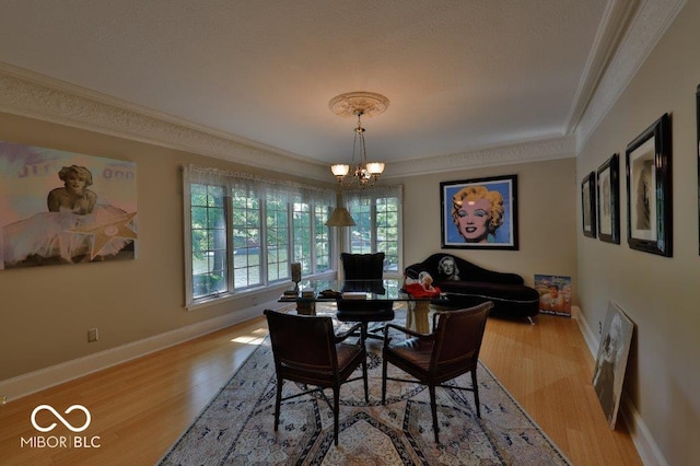 dining area with an inviting chandelier, crown molding, and hardwood / wood-style flooring