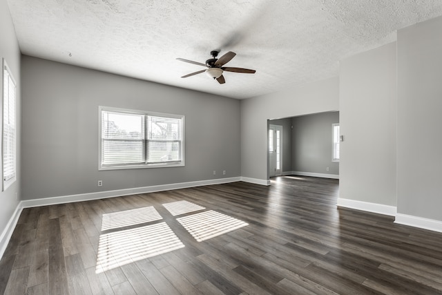 spare room featuring dark hardwood / wood-style floors, ceiling fan, and a textured ceiling