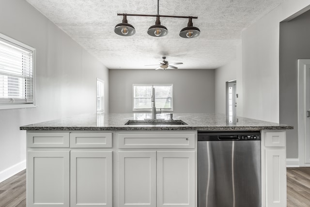 kitchen featuring sink, stone counters, white cabinetry, and stainless steel dishwasher