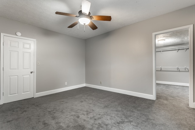 unfurnished bedroom featuring a closet, ceiling fan, dark carpet, and a textured ceiling