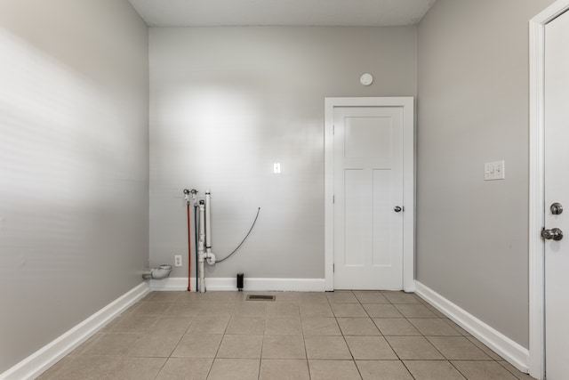 clothes washing area with hookup for a washing machine and light tile floors