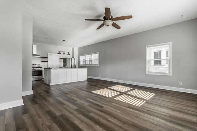 unfurnished living room with dark hardwood / wood-style flooring, ceiling fan, and a textured ceiling