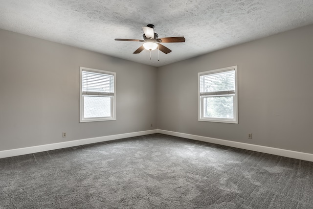 carpeted spare room with a textured ceiling, a wealth of natural light, and ceiling fan