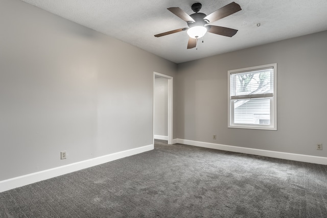 spare room featuring a textured ceiling, ceiling fan, and dark colored carpet