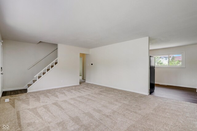 unfurnished living room featuring light carpet