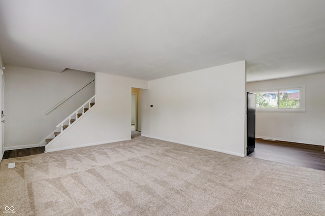 unfurnished living room featuring light colored carpet