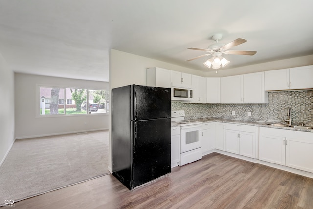 kitchen featuring white appliances, sink, backsplash, light carpet, and ceiling fan