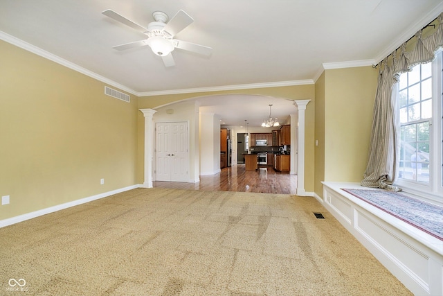 interior space featuring dark hardwood / wood-style floors, ornamental molding, ceiling fan with notable chandelier, and ornate columns