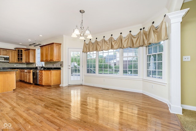 kitchen with decorative backsplash, ornamental molding, stainless steel appliances, and a wealth of natural light