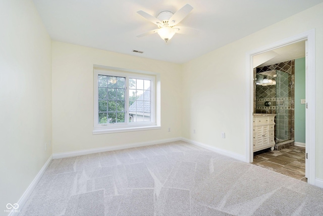 unfurnished bedroom featuring ceiling fan, light colored carpet, and connected bathroom