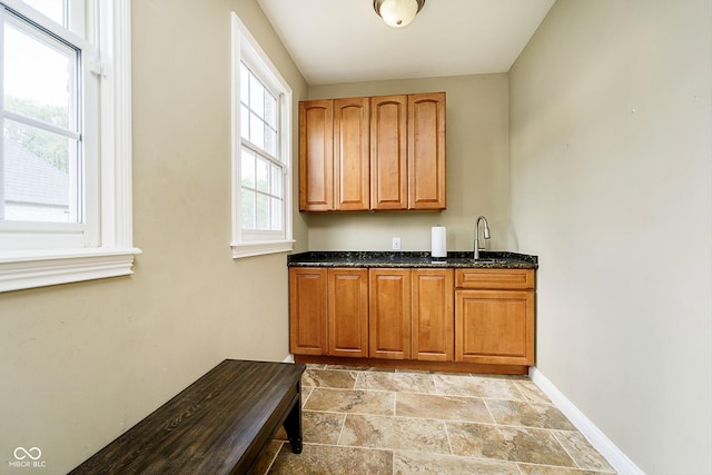 bar with dark stone countertops and sink