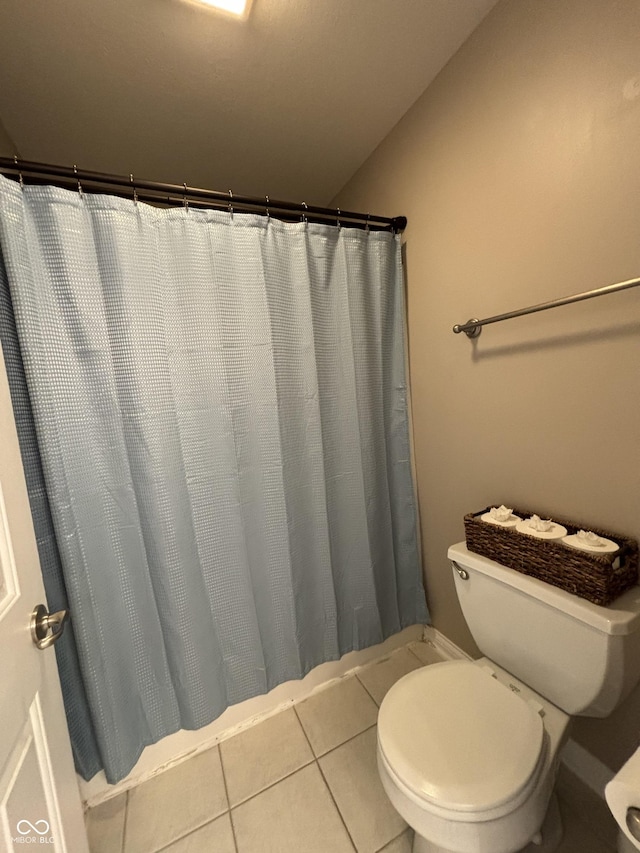 bathroom featuring tile patterned floors, a shower with curtain, toilet, and vaulted ceiling