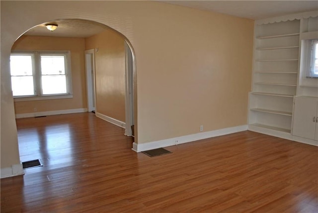 spare room featuring hardwood / wood-style floors and built in features