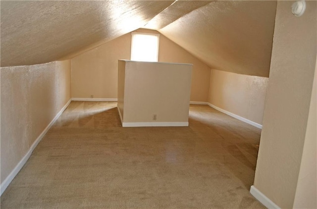 additional living space with carpet floors, a textured ceiling, and lofted ceiling