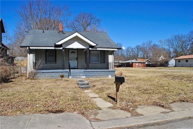 bungalow featuring covered porch and a front lawn