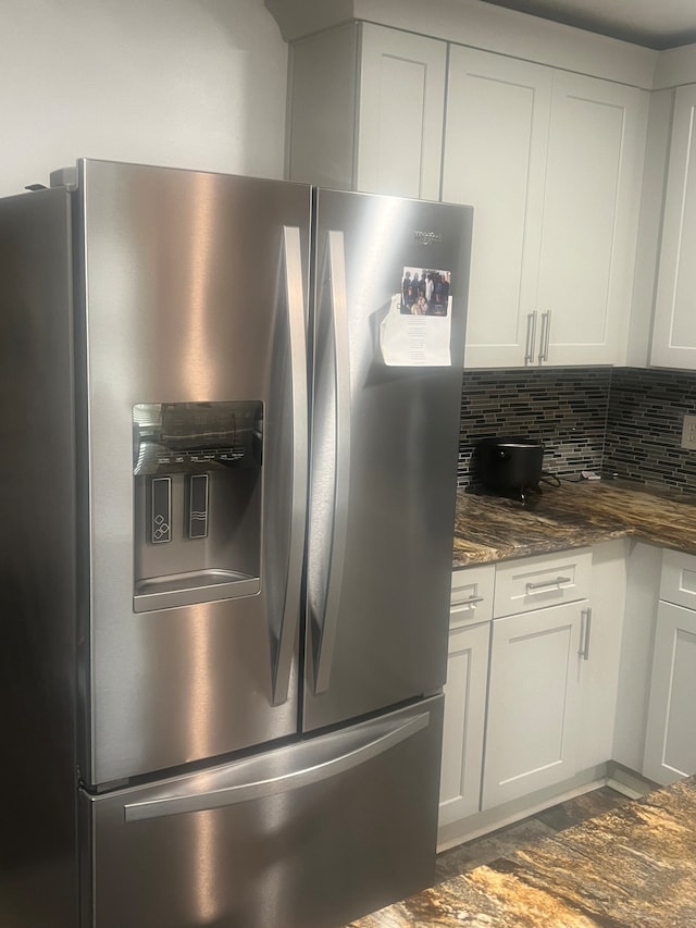 kitchen with white cabinets, tasteful backsplash, hardwood / wood-style floors, stainless steel fridge with ice dispenser, and dark stone countertops