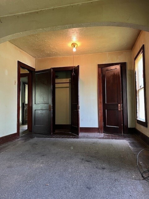 spare room with dark colored carpet and a textured ceiling