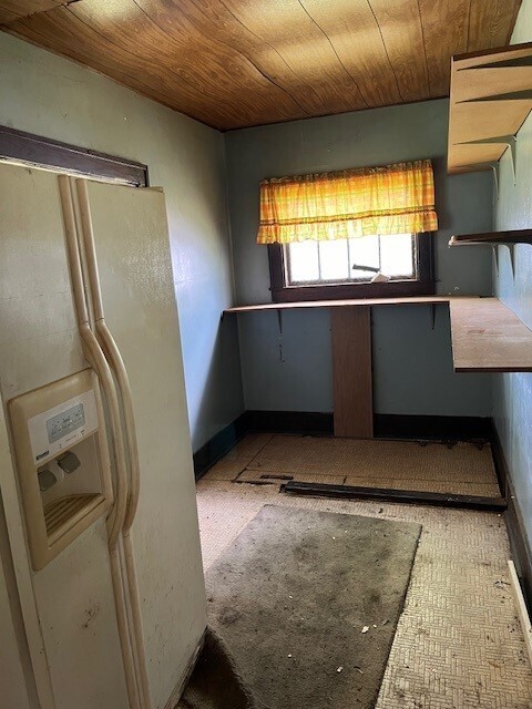 kitchen with white fridge with ice dispenser and wood ceiling