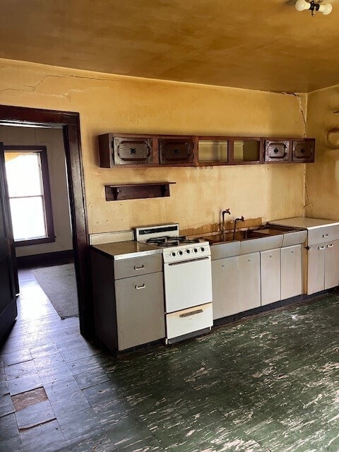 kitchen featuring white stove and sink