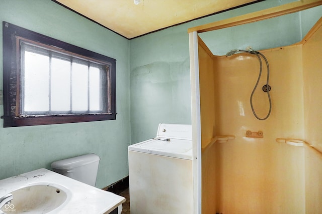 bathroom featuring vanity, toilet, and washer / dryer