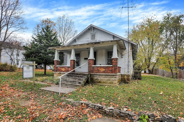 view of front of home with a porch and a front yard