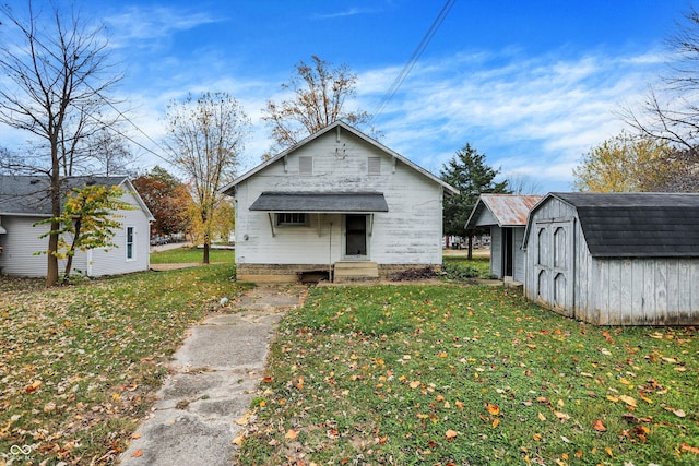 view of front of property with a storage unit and a front yard