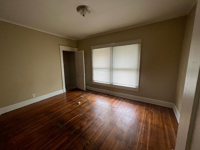 unfurnished room with dark wood-type flooring