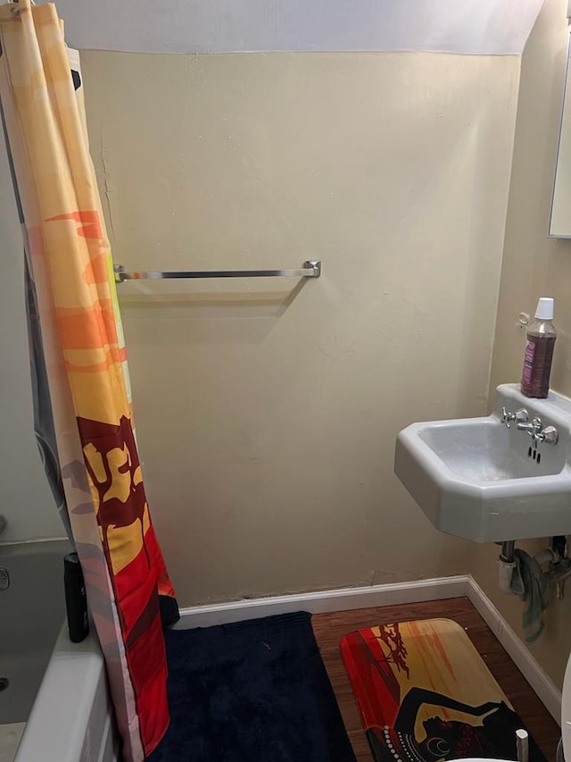 bathroom featuring hardwood / wood-style floors, sink, and shower / bath combo