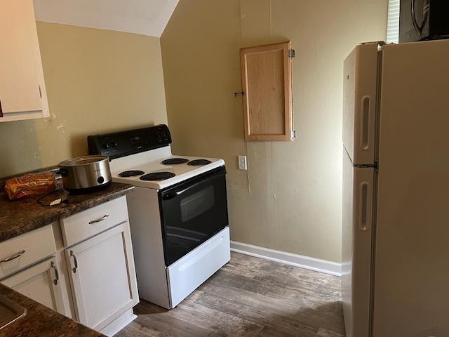 kitchen featuring white cabinets, dark hardwood / wood-style flooring, and white appliances