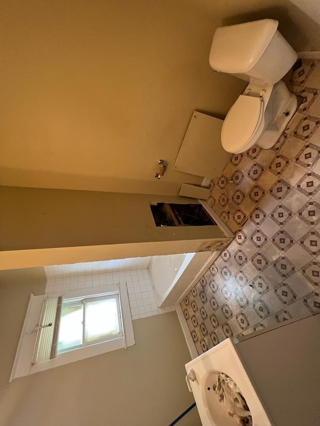 bathroom featuring tile flooring and toilet