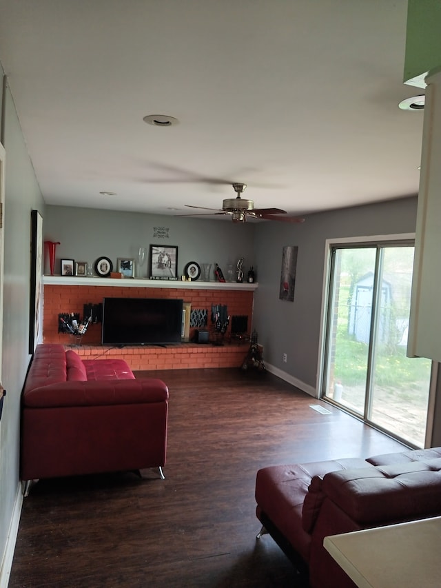 living room featuring ceiling fan and dark wood-type flooring