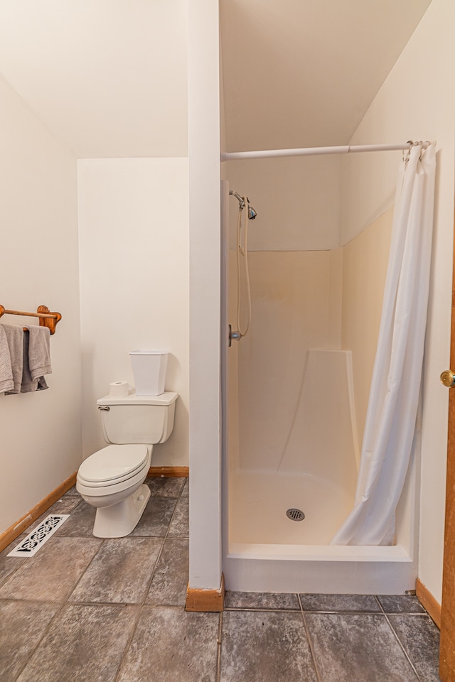 bathroom featuring toilet and curtained shower