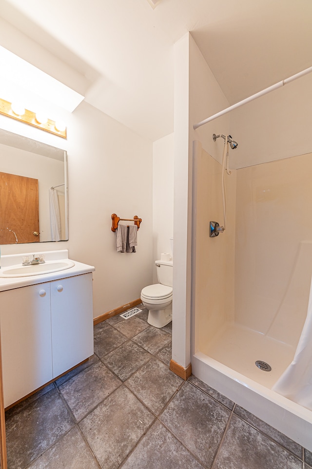 bathroom featuring toilet, vanity, and curtained shower