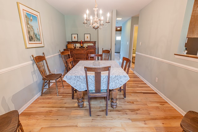 dining room featuring a notable chandelier and light wood-type flooring